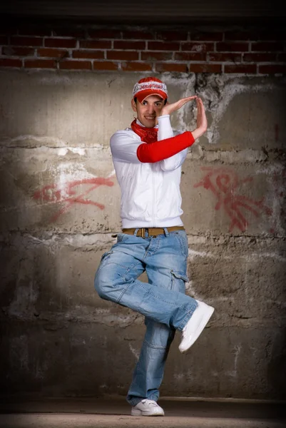 stock image Hip hop boy dancing in modern style over grey brick wall