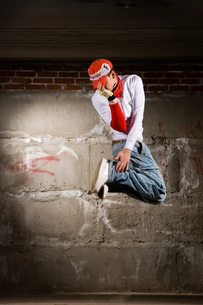 stock image Hip hop boy dancing in modern style over grey brick wall