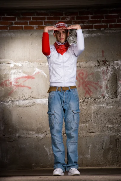 Hip hop dreng danser i moderne stil over grå mursten væg - Stock-foto