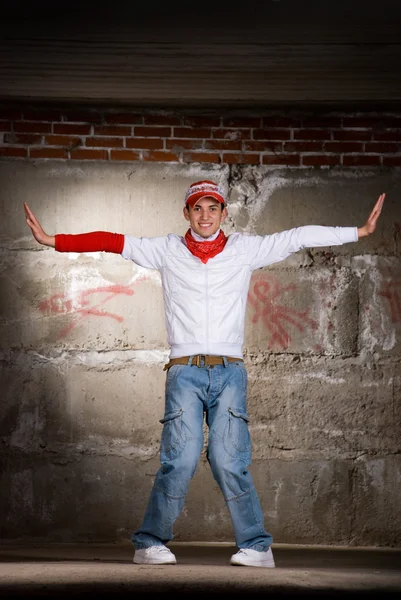 stock image Hip hop boy dancing in modern style over grey brick wall