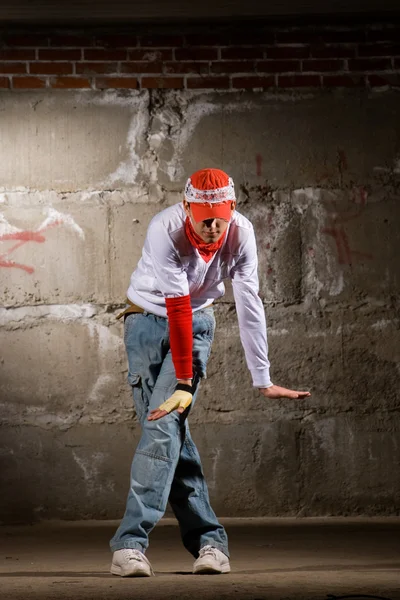 Hip hop chico bailando en estilo moderno sobre la pared de ladrillo gris —  Fotos de Stock