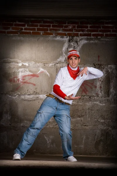 Hip hop menino dançando em estilo moderno sobre parede de tijolo cinza — Fotografia de Stock