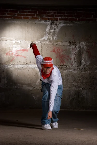 Hip hop menino dançando em estilo moderno sobre parede de tijolo cinza — Fotografia de Stock