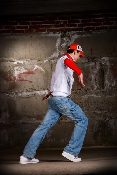 Hiphop pojke dans i modern stil över grå tegelvägg — Stockfoto