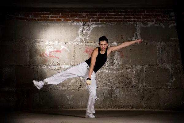 Hip hop ragazzo danza in stile moderno su muro di mattoni grigi — Foto Stock