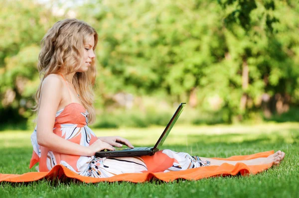 Νεαρή γυναίκα με φορητό υπολογιστή στο πάρκο — Φωτογραφία Αρχείου