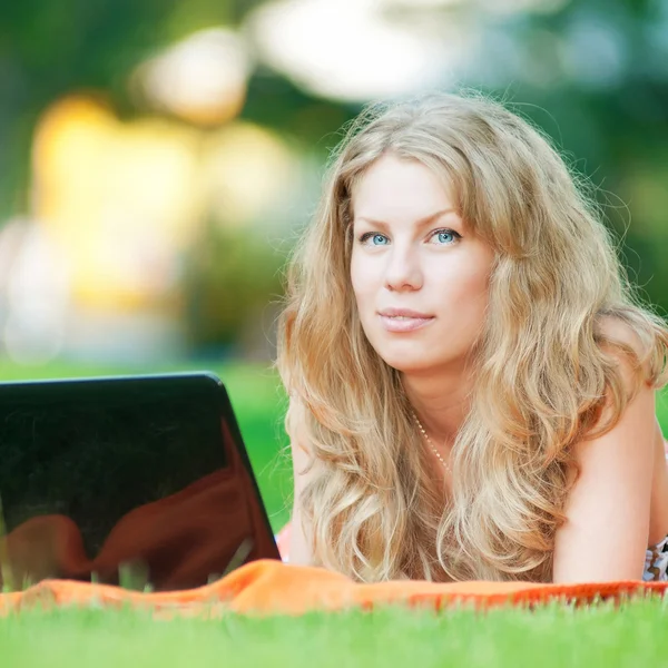 Молода жінка з ноутбуком у парку — стокове фото