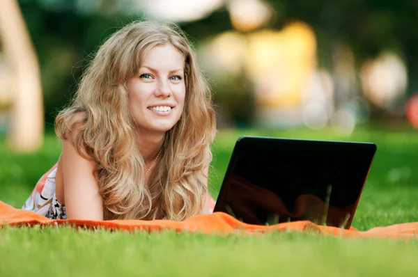 Young woman with laptop at park — Stock Photo, Image