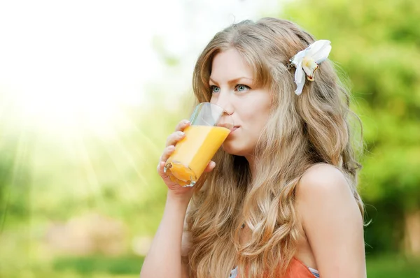 Smiling woman drinking orange juice — Stock Photo, Image