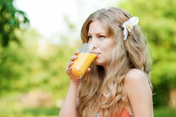 stock image Smiling woman drinking orange juice