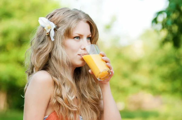 Χαμογελώντας γυναίκα πίνοντας χυμό πορτοκαλιού — Φωτογραφία Αρχείου