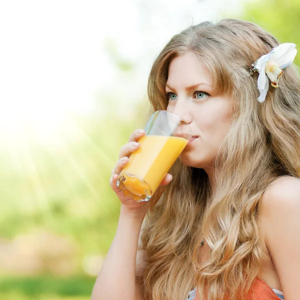 Mujer sonriente bebiendo jugo de naranja —  Fotos de Stock