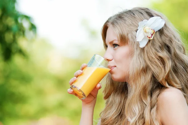 Mujer sonriente bebiendo jugo de naranja —  Fotos de Stock