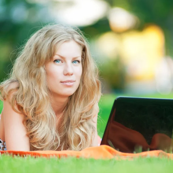 Young woman with laptop at park Stock Picture