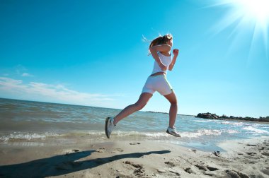 Sport woman running on beach