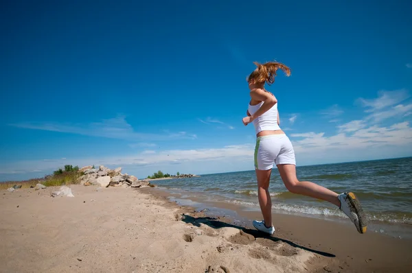 Femme sportive courant sur la côte de la mer — Photo