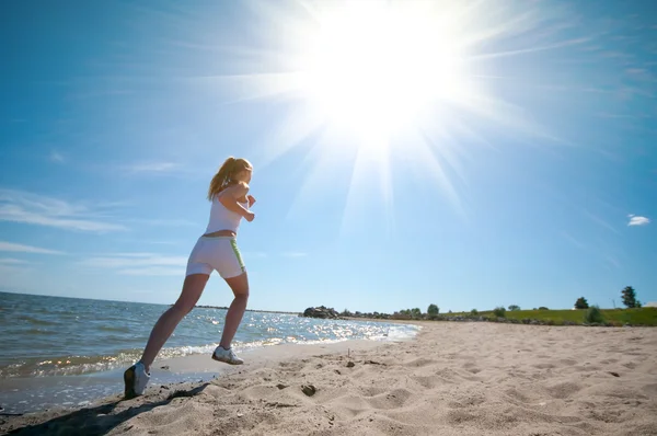 Sport nő fut a tenger partján — Stock Fotó