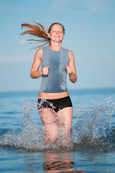 Спортивная женщина бегает в воде — стоковое фото