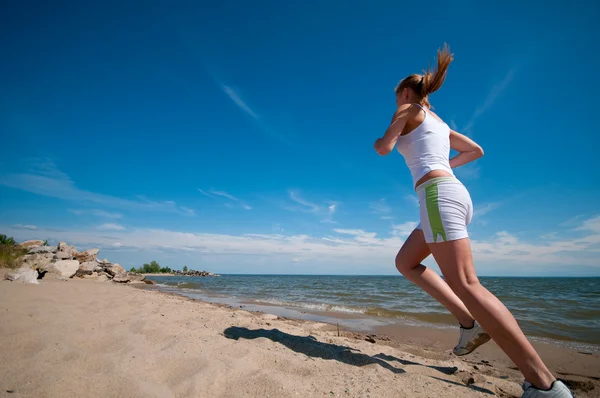 Deporte mujer corriendo en la costa del mar —  Fotos de Stock