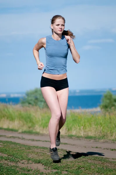 Молодая спортсменка бегает в солнечный день — стоковое фото
