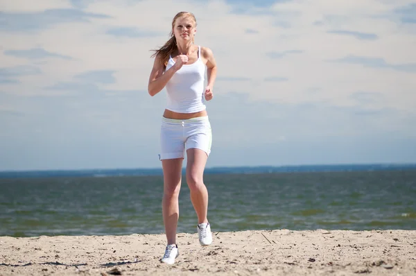 海沿岸を走っているスポーツ女性 — ストック写真