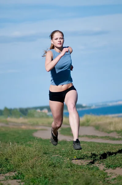 晴れた日に走っている若いスポーツ女性 — ストック写真