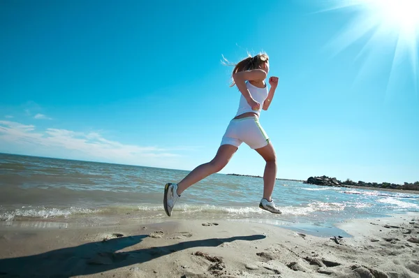 Donna sportiva che corre sulla spiaggia — Foto Stock