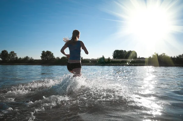 Femme sportive courant dans l'eau — Photo