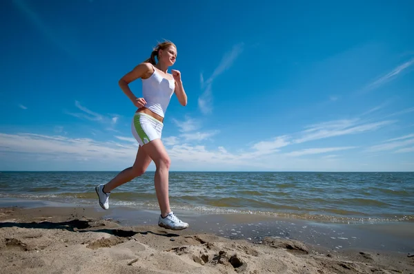 stock image Sport woman running in sea coast