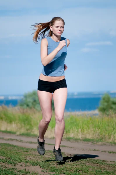 Ung sport kvinna kör på solig dag — Stockfoto