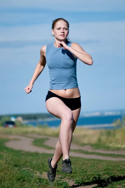 Αθλητισμός εφηβικό κορίτσι που τρέχει πάνω από το γαλάζιο του ουρανού — Φωτογραφία Αρχείου