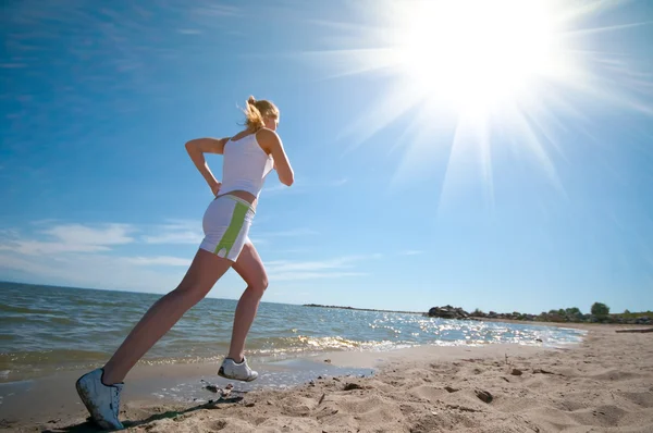Sport nő fut a tenger partján — Stock Fotó