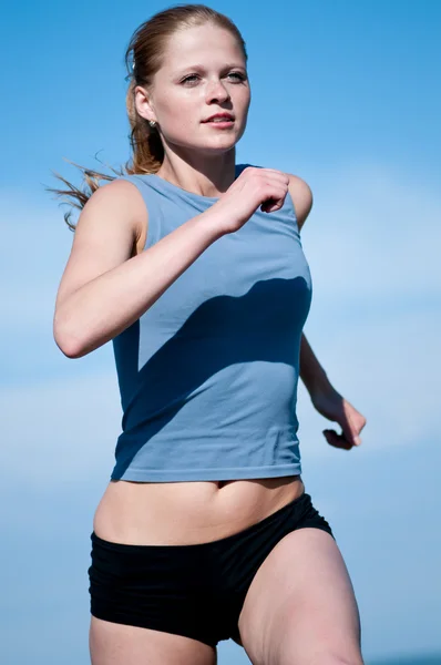 Спортивная девочка-подросток бежит по голубому небу — стоковое фото