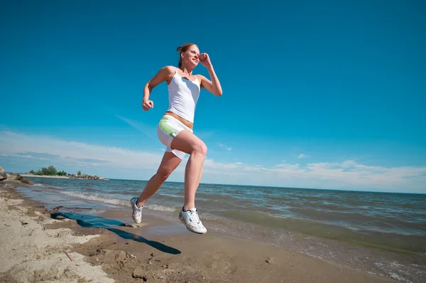 Sport woman running in sea coast