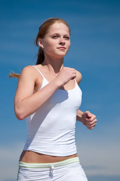 Спортивна жінка біжить на пляжі — стокове фото