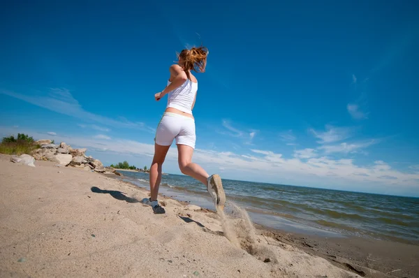 Sport woman running on beach — Stockfoto