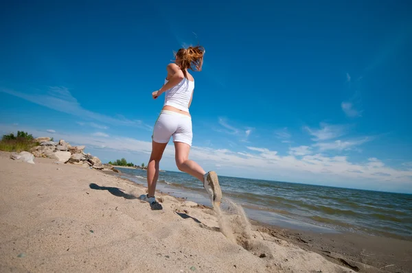 Donna sportiva che corre sulla spiaggia — Foto Stock