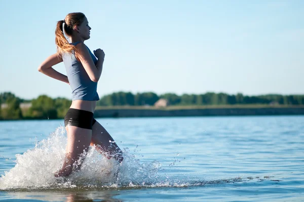 Donna sportiva che corre in acqua — Foto Stock