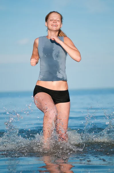 Спортивная женщина бегает в воде — стоковое фото