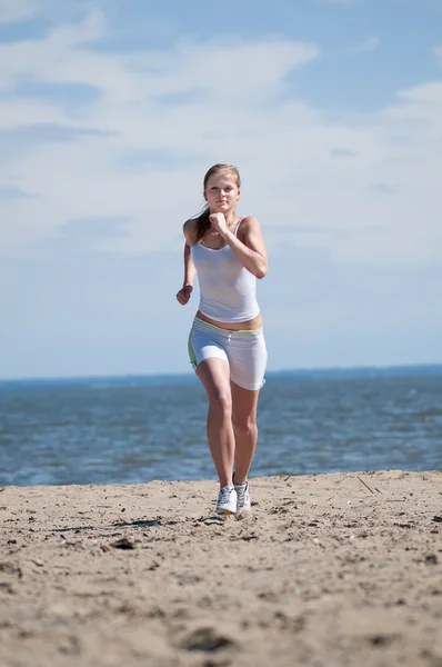 Sport kvinna kör på stranden — Stockfoto