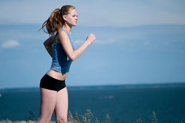 Молода спортивна жінка біжить у сонячний день — стокове фото