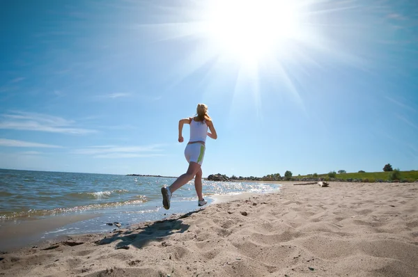 Sport woman running on beach — Stok fotoğraf