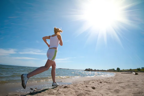 Sportlerin läuft am Strand — Stockfoto