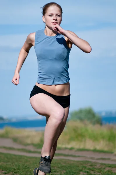 Νέος αθλητισμός γυναίκα που τρέχει σε ηλιόλουστη ημέρα — Φωτογραφία Αρχείου