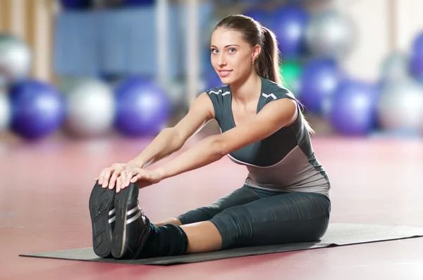 Kobieta robi rozciągających ćwiczeń fitness siłownia sport. Joga — Zdjęcie stockowe