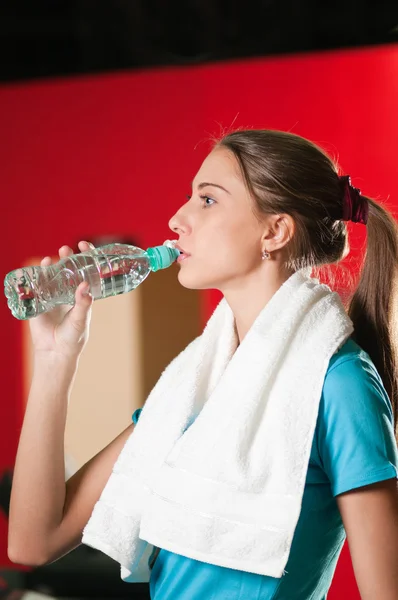 Vrouw op de sportschool drinkwater — Stockfoto