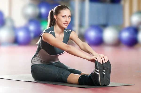 Жінка займається розтягуванням фізичних вправ у спортивному тренажерному залі. Йога — стокове фото