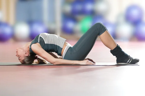 Mujer haciendo ejercicio físico de estiramiento en el gimnasio deportivo. Yoga — Foto de Stock