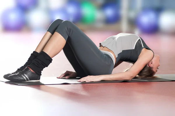 Γυναίκα που κάνει το τέντωμα fitness άσκηση στο γυμναστήριο του αθλητισμού. γιόγκα — Φωτογραφία Αρχείου