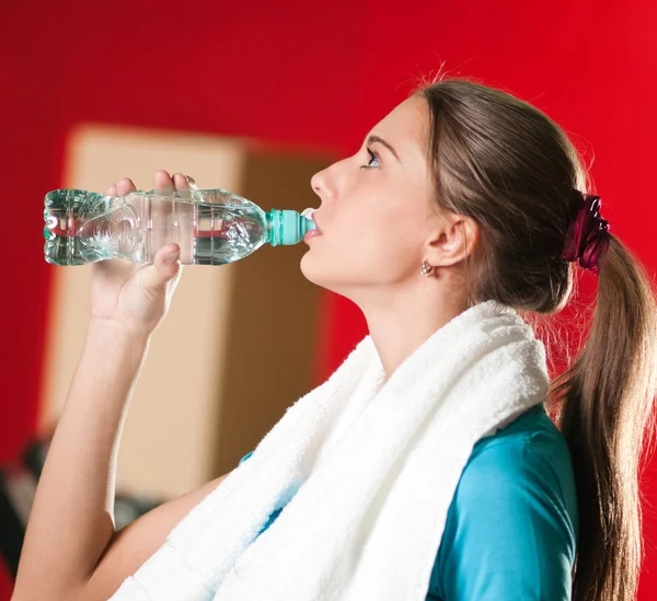 Vrouw op de sportschool drinkwater — Stockfoto